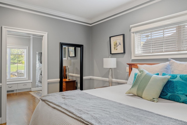 bedroom with crown molding and wood-type flooring