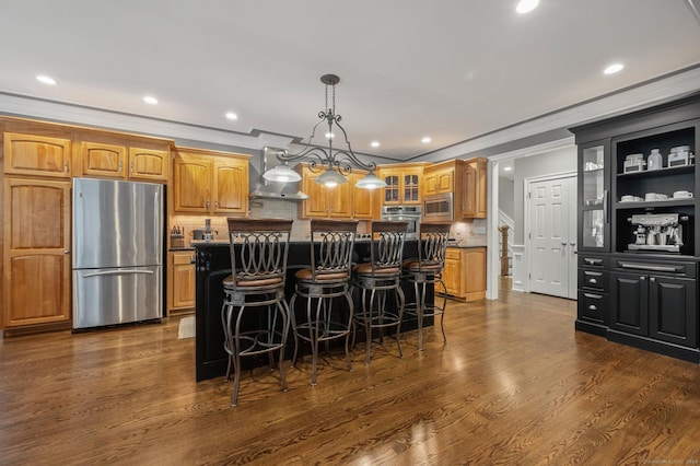 kitchen featuring a kitchen island, a breakfast bar, dark hardwood / wood-style flooring, stainless steel appliances, and crown molding