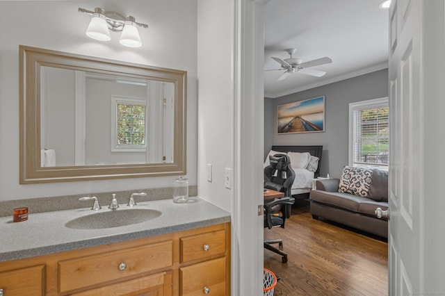 bathroom with ornamental molding, hardwood / wood-style floors, vanity, and ceiling fan