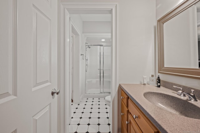 bathroom with vanity, a shower with shower door, and toilet