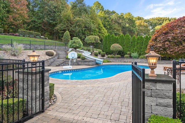 view of pool featuring a water slide and a patio area