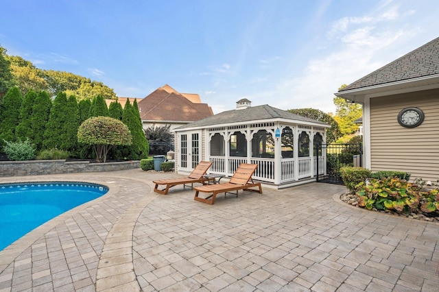 view of pool with a gazebo, an outdoor structure, and a patio area