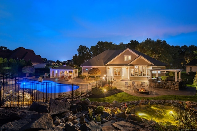 pool at dusk featuring a patio and a fire pit