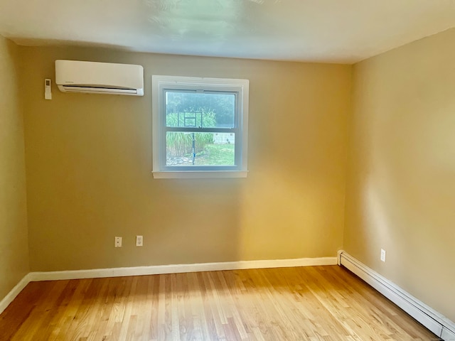 empty room featuring a baseboard radiator, light wood-type flooring, and an AC wall unit