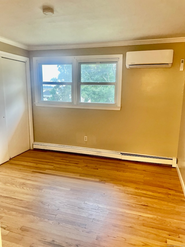 interior space featuring light wood-type flooring, ornamental molding, baseboard heating, and a wall unit AC