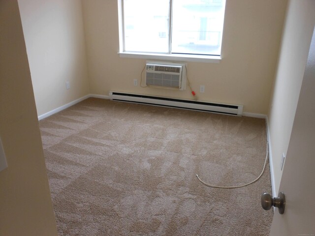 empty room featuring baseboard heating, a wall mounted air conditioner, and light carpet