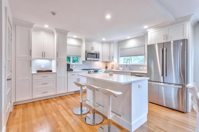 82 Thimble Island Rd, Branford, CT 06405 - kitchen featuring stainless steel appliances, white cabinetry, light wood finished floors, a kitchen island, and recessed lighting