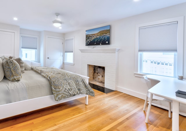 bedroom with wood-type flooring and a fireplace