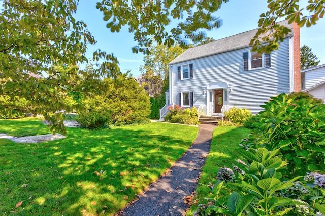 colonial inspired home featuring a front lawn