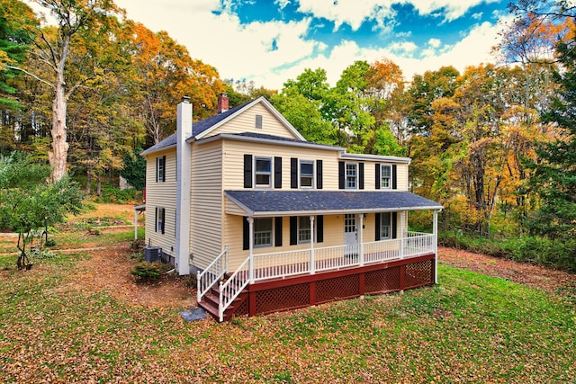 view of front facade with cooling unit, a front lawn, and covered porch