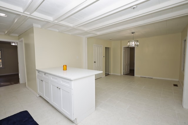 kitchen featuring white cabinets, coffered ceiling, hanging light fixtures, a chandelier, and beam ceiling