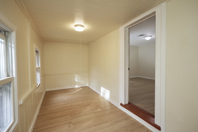 empty room featuring ornamental molding and light wood-type flooring