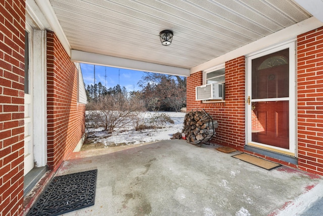 snow covered patio featuring cooling unit