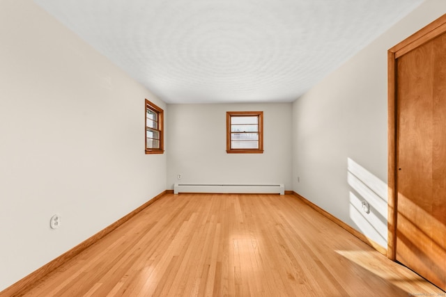 empty room featuring light hardwood / wood-style flooring and a baseboard radiator