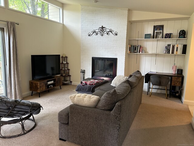 living room featuring a fireplace, vaulted ceiling, and light carpet