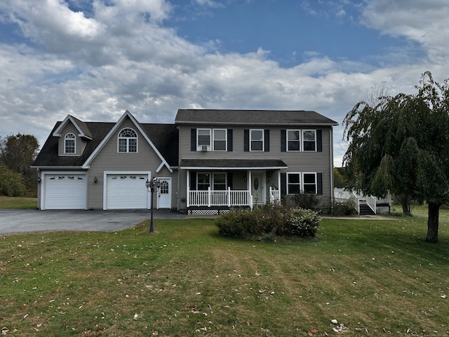 colonial home featuring a front yard, a garage, and a porch