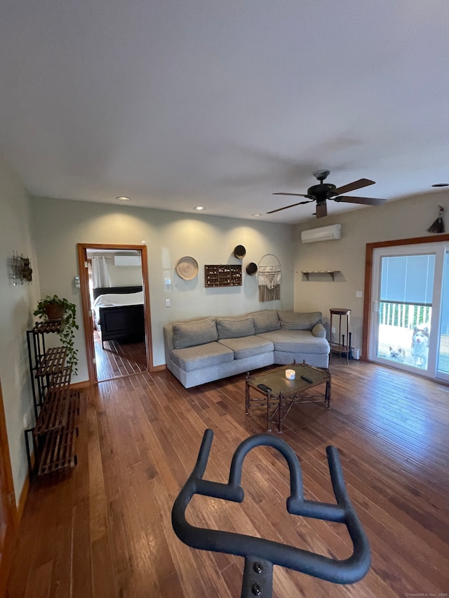 living room featuring a wall mounted AC, hardwood / wood-style floors, and ceiling fan