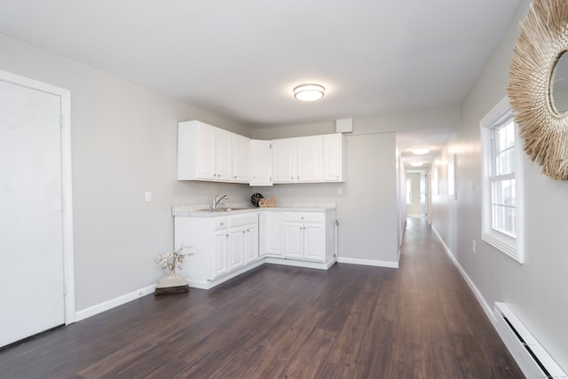 kitchen with white cabinetry, dark hardwood / wood-style floors, sink, and a baseboard radiator