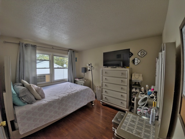 bedroom with a textured ceiling and dark wood-type flooring