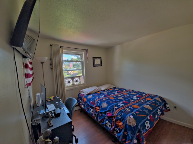 bedroom featuring a textured ceiling and dark hardwood / wood-style floors