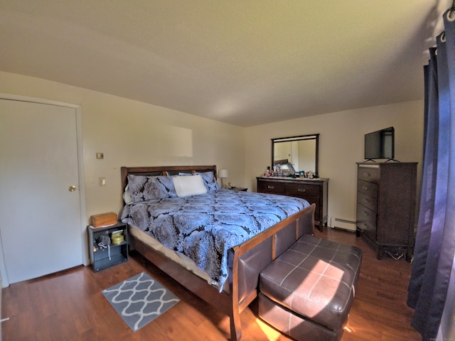 bedroom featuring baseboard heating and dark wood-type flooring