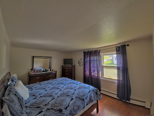 bedroom featuring a textured ceiling, a baseboard radiator, and hardwood / wood-style floors