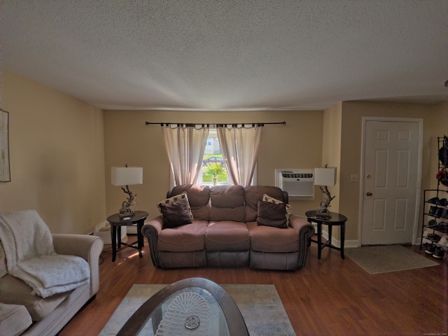 living room with an AC wall unit, a textured ceiling, and dark hardwood / wood-style flooring