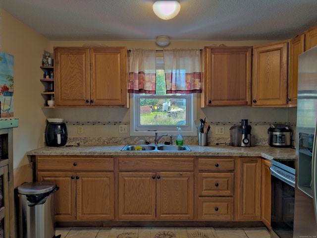 kitchen featuring appliances with stainless steel finishes, decorative backsplash, sink, and light tile patterned floors