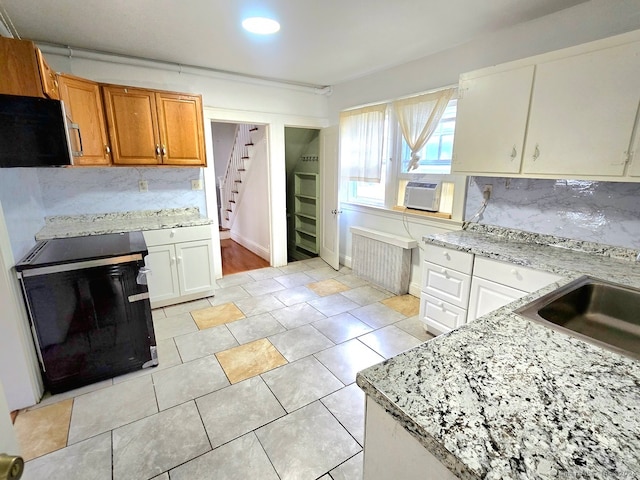 kitchen featuring tasteful backsplash, white cabinets, electric range oven, radiator heating unit, and cooling unit