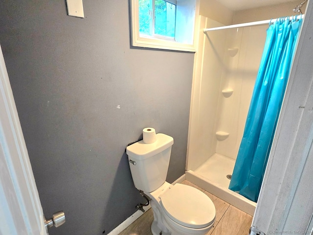 bathroom featuring a shower with curtain, tile patterned flooring, and toilet