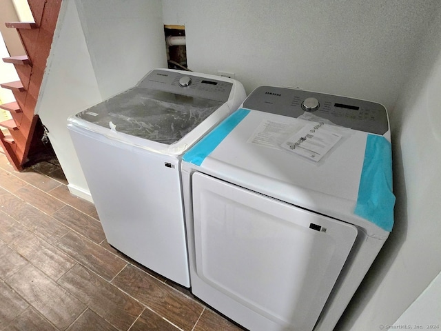 clothes washing area with hardwood / wood-style floors and independent washer and dryer