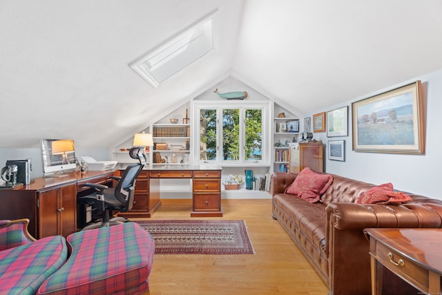 office featuring built in shelves, light hardwood / wood-style flooring, and lofted ceiling with skylight