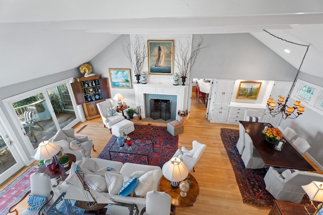 living room with high vaulted ceiling, light wood-type flooring, and beam ceiling