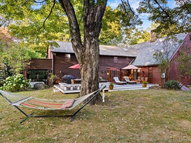 back of property featuring a yard and a deck