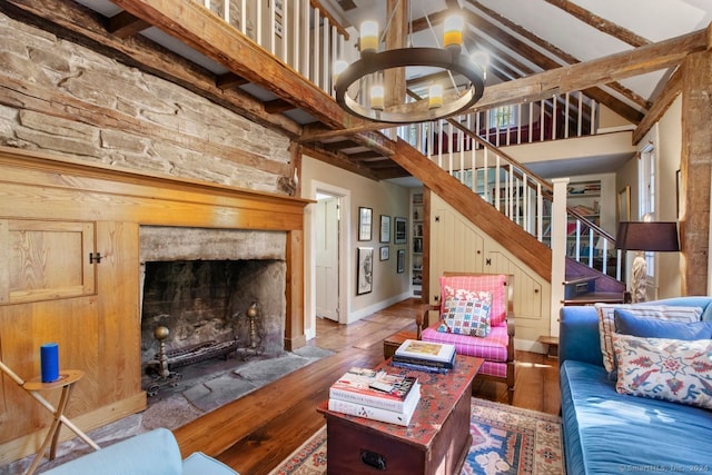 living room with hardwood / wood-style floors, beamed ceiling, a chandelier, and high vaulted ceiling