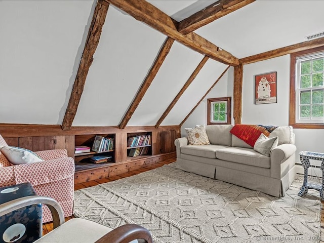 living room featuring light hardwood / wood-style flooring and vaulted ceiling with beams