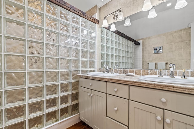 bathroom featuring tile walls, walk in shower, and vanity