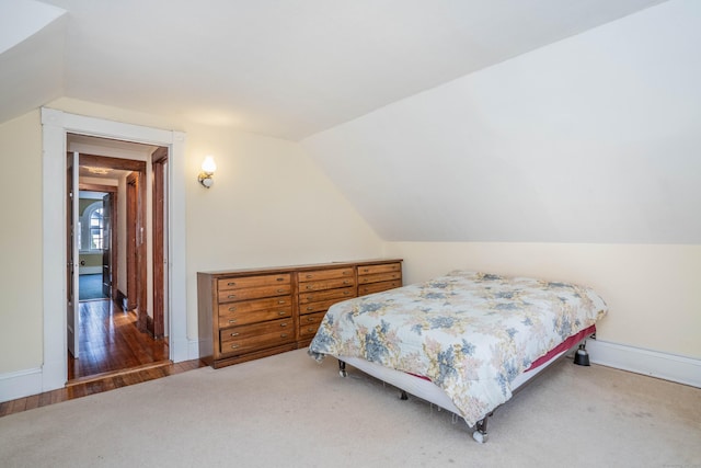 bedroom featuring carpet floors and vaulted ceiling