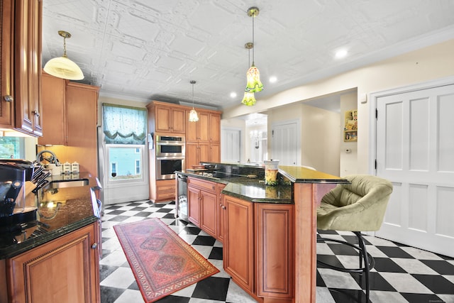 kitchen with sink, a kitchen island, decorative light fixtures, appliances with stainless steel finishes, and a breakfast bar