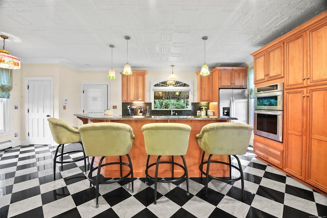 kitchen featuring appliances with stainless steel finishes, hanging light fixtures, crown molding, and a center island