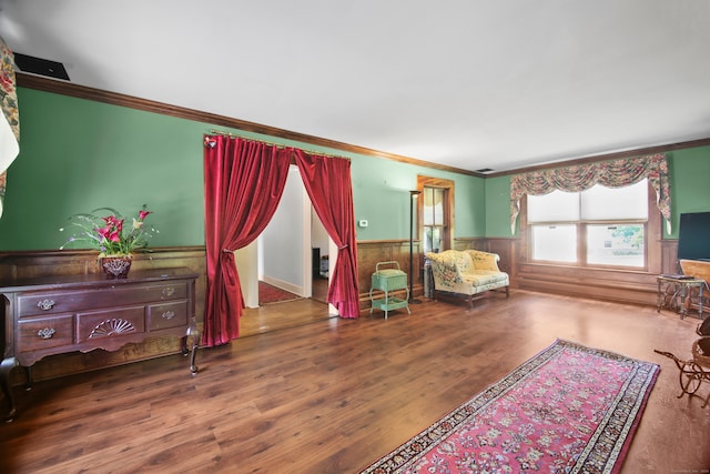 sitting room with ornamental molding and hardwood / wood-style floors