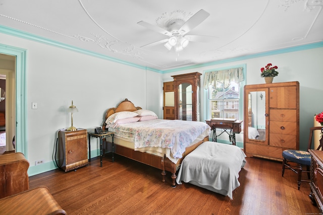 bedroom with crown molding, dark hardwood / wood-style flooring, and ceiling fan