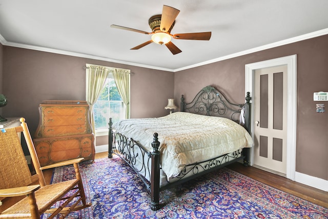 bedroom with ornamental molding, dark hardwood / wood-style floors, and ceiling fan