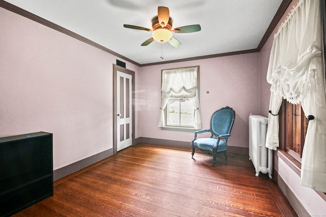 living area featuring ornamental molding, dark hardwood / wood-style flooring, radiator heating unit, and ceiling fan