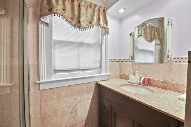 bathroom with walk in shower, tile walls, and vanity