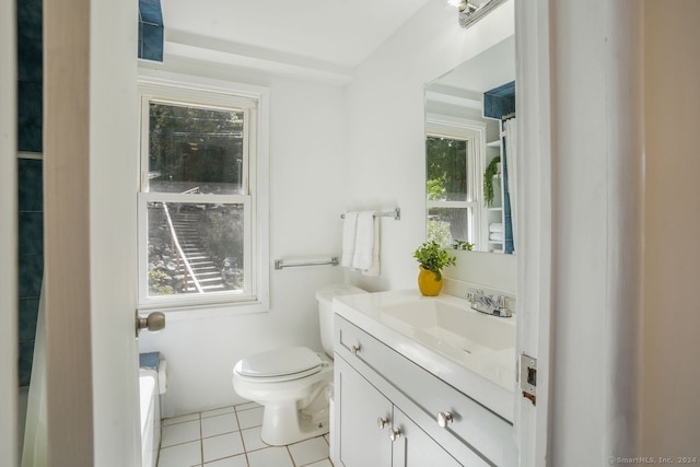 bathroom featuring toilet, vanity, a healthy amount of sunlight, and tile patterned flooring