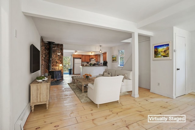 living room with light hardwood / wood-style floors and a wood stove