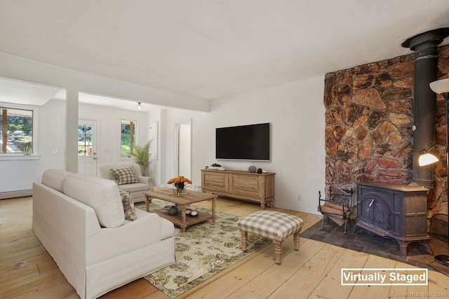 living room with light hardwood / wood-style flooring and a wood stove