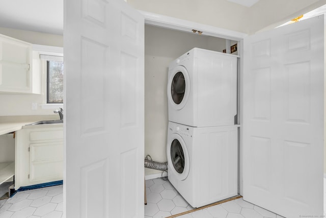 laundry room featuring sink and stacked washer / dryer