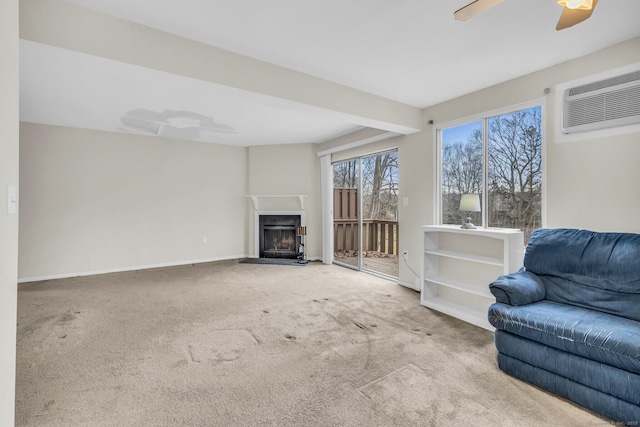 carpeted living room with an AC wall unit and ceiling fan